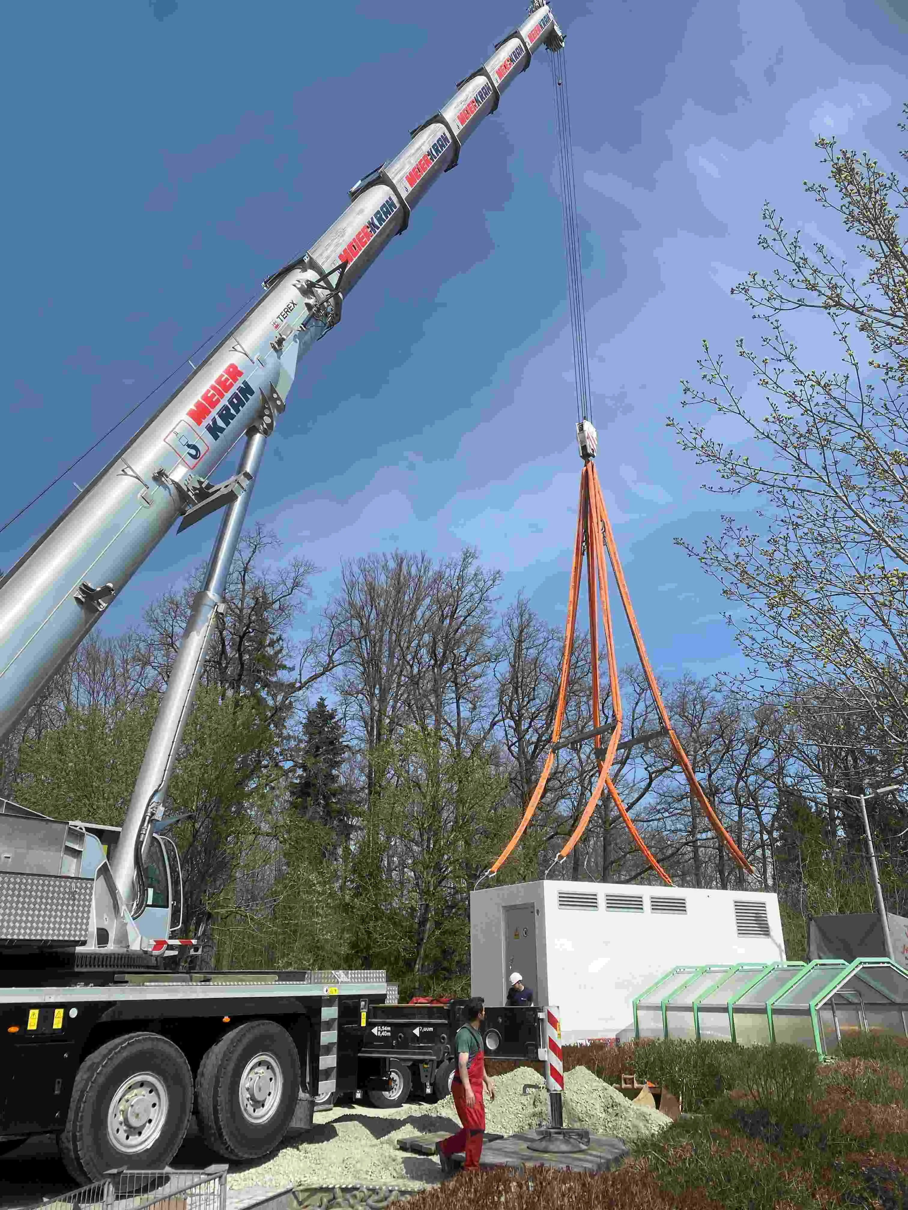 Elektrifizierte Baumaschinen und schwere Nutzfahrzeuge auf Baustelle mit leistungsstarker Ladeinfrastruktur